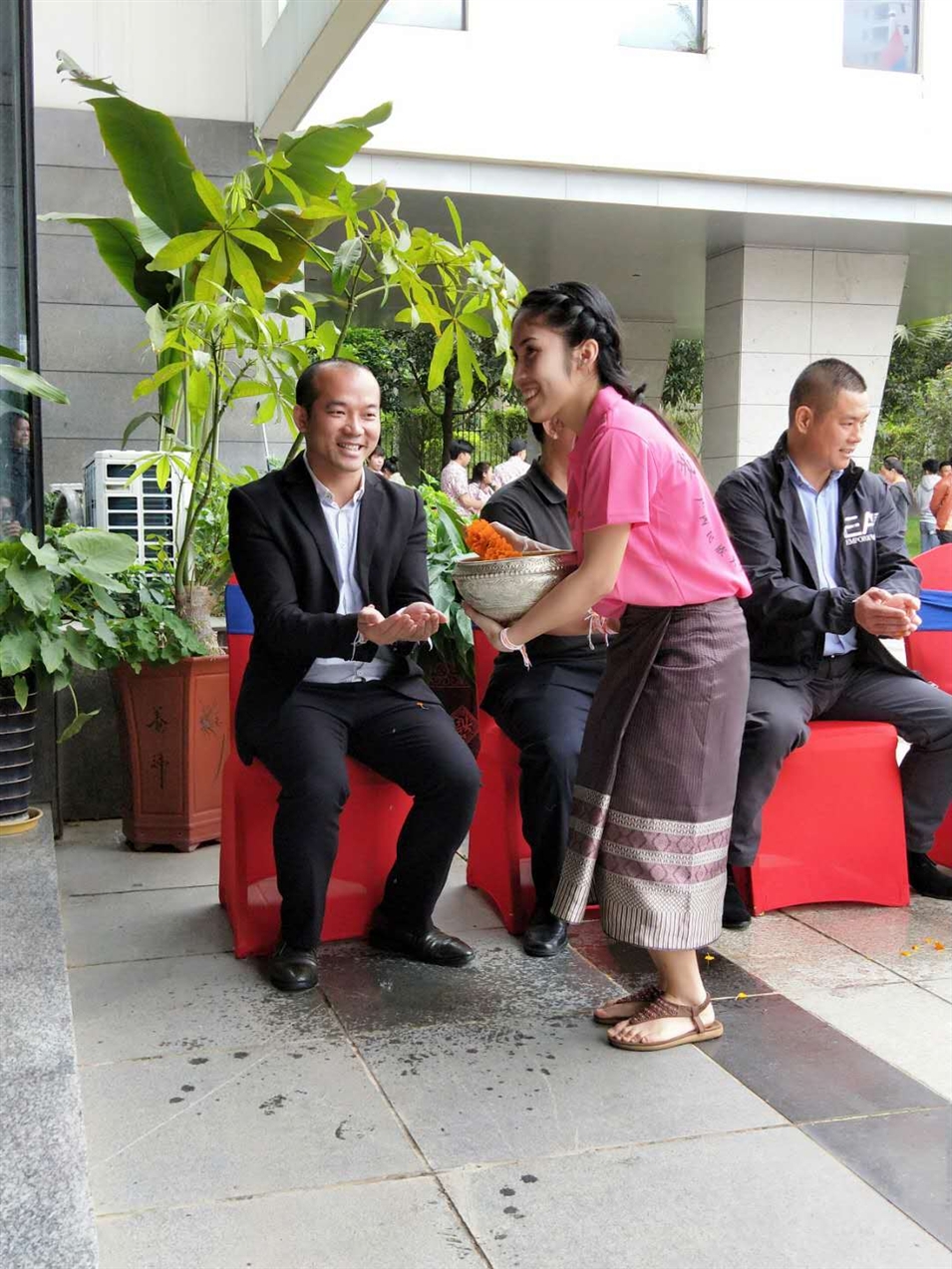 老撾駐廣西留學(xué)生代表將浸有花瓣的香水灑客人的手上，表示對嘉賓的美好祝福（圖一）