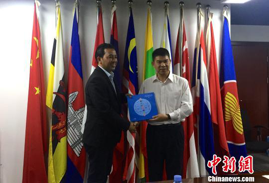 中國—東盟博覽會秘書處副秘書長黃平西（右）與柬埔寨新聞部新聞與傳播總司副總司長春占皮侖（左）互贈禮物。